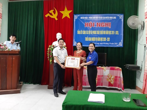 Đồng chí Đinh Trung Hiếu và Đồng Chí Đinh Thị Xuân Hương trao bằng khen của Trung ương Đoàn cho Liên đội trường THCS Long Hiệp