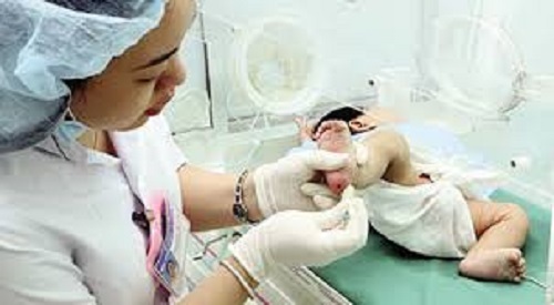 Bác sỹ lấy mẫu máu gót chân trẻ sơ sinh để gửi đi sàng lọc