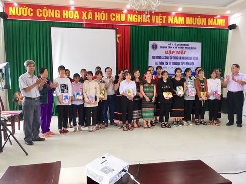 Lãnh đạo Chi cục Dân số tỉnh và TTYT huyện trao quà cho Trẻ em gái